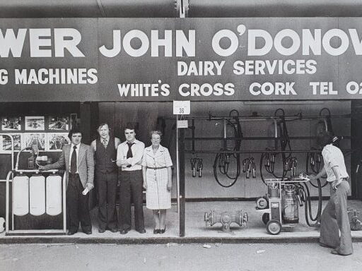 Black and white photo of the original Dairy Services shop including five people who work there